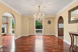 Hardwood-finish flooring, arched doorways, crown molding, and a crystal chandelier - 