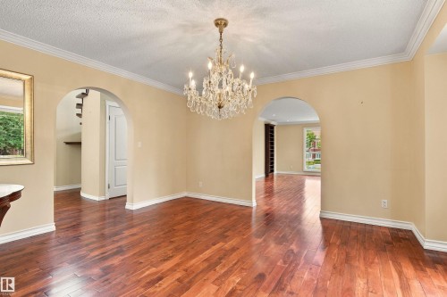 Hardwood flooring, crystal chandelier, arched doorways, crown molding, and substantial baseboards - 14103 60 Avenue Nw, Edmonton, AB 
