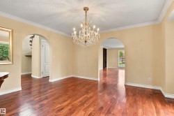 Hardwood flooring, crystal chandelier, arched doorways, crown molding, and substantial baseboards - 