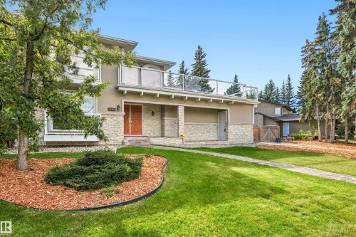 Stone veneer facade with a covered entry, glass panel balcony, and double entry doors - 14103 60 Avenue Nw, Edmonton, AB 