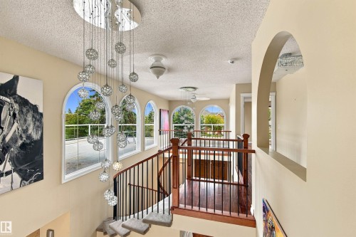 Spiral staircase with wood-finish handrail, wrought iron balusters, and carpeted treads - 14103 60 Avenue Nw, Edmonton, AB 