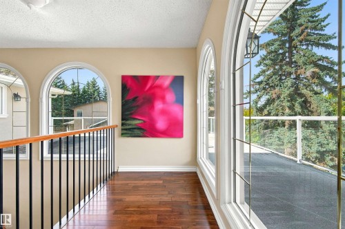 Hardwood-finish flooring, arched windows with grilles, and a wrought iron and wood handrail - 14103 60 Avenue Nw, Edmonton, AB 