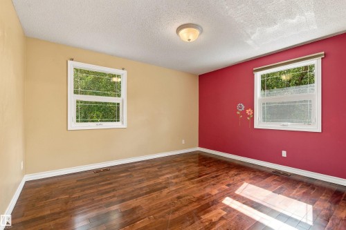 Rich wood-finish flooring with white baseboards - 14103 60 Avenue Nw, Edmonton, AB 