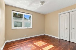 Wood-finish flooring, neutral wall tones, a double-panel window, and bi-fold closet doors - 