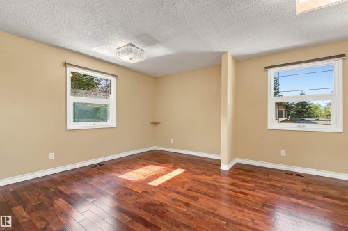 Hardwood flooring throughout, two large windows, white trim, recessed lighting, and a built-in wall shelf - 14103 60 Avenue Nw, Edmonton, AB 
