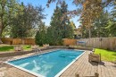 In-ground swimming pool with a paved surround, wood privacy fencing, and mature trees - 14103 60 Avenue Nw, Edmonton, AB 