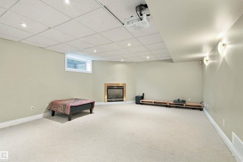 Recessed lighting, drop ceiling, wall-mounted sconces, and a built-in fireplace with a metallic trim - 14103 60 Avenue Nw, Edmonton, AB 