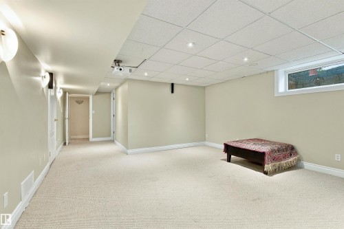 Carpeted flooring, recessed lighting, and wall sconces illuminate this versatile space - 14103 60 Avenue Nw, Edmonton, AB 