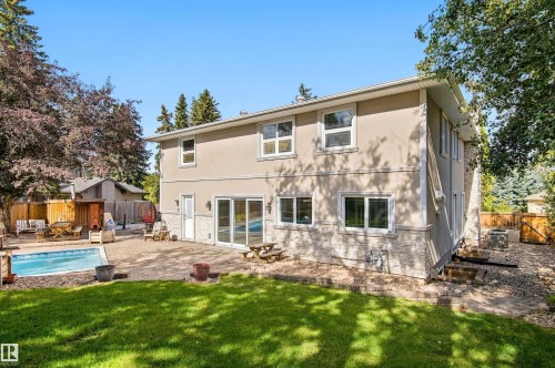 Rear exterior featuring a swimming pool, paved patio, and sliding glass doors - 14103 60 Avenue Nw, Edmonton, AB 