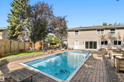 In-ground swimming pool with a surrounding paver patio and a stucco exterior - 14103 60 Avenue Nw, Edmonton, AB 