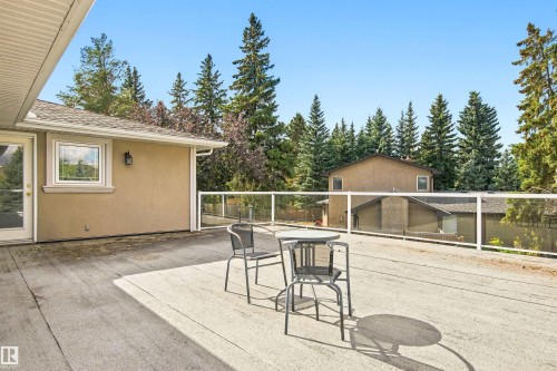 Expansive outdoor deck with a glass railing system and stucco exterior - 14103 60 Avenue Nw, Edmonton, AB 