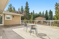 Expansive outdoor deck with a glass railing system and stucco exterior - 