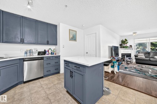 Kitchen featuring blue cabinetry, white countertops, and stainless steel appliances - #133 16311 95 St Nw, Edmonton, AB 