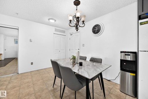 Tile flooring, white walls, ceiling-mounted light fixture, white interior doors, and a mirrored closet door - #133 16311 95 St Nw, Edmonton, AB 