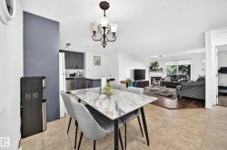 Open-concept dining area with tile flooring and a decorative chandelier - 