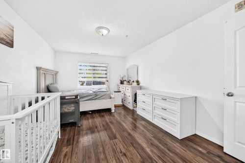 Wood-finish flooring with white walls and a white paneled door - #133 16311 95 St Nw, Edmonton, AB 