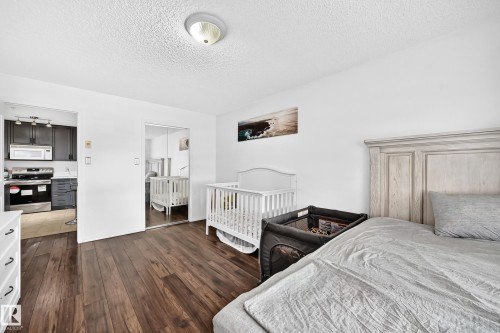 Wood-finish flooring throughout, white walls, and a ceiling-mounted light fixture - #133 16311 95 St Nw, Edmonton, AB 