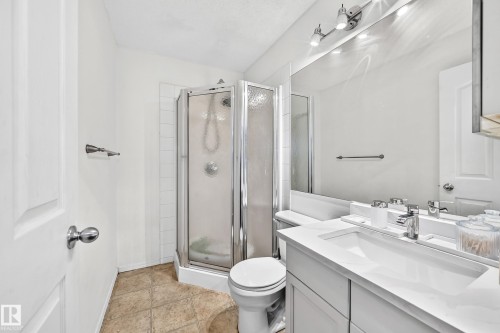 White vanity with integrated sink, chrome faucet, and a large wall-mounted mirror - #133 16311 95 St Nw, Edmonton, AB 