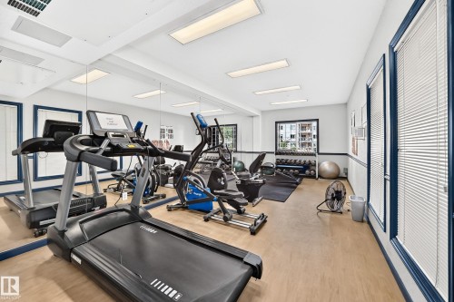 Dedicated fitness area featuring a treadmill, elliptical, and free weights, complemented by expansive wall mirrors and natural light - #133 16311 95 St Nw, Edmonton, AB 