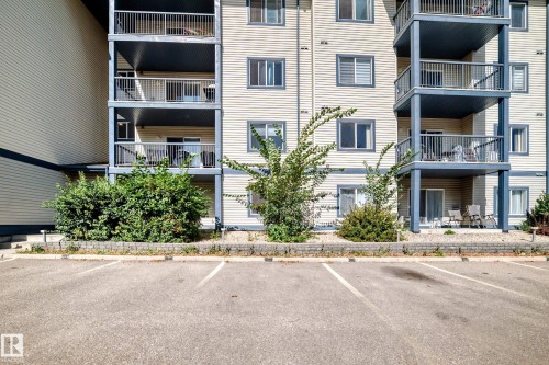 Multi-story building featuring stacked balconies with metal railings, horizontal siding, and multiple windows - #133 16311 95 St Nw, Edmonton, AB 