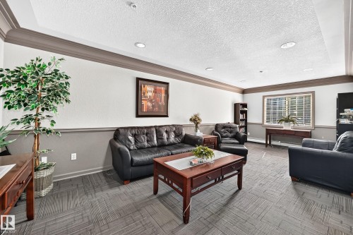 Recessed lighting illuminating the room, crown molding detailing, textured wall finishes, a window with horizontal blinds, and patterned carpet flooring - #133 16311 95 St Nw, Edmonton, AB 