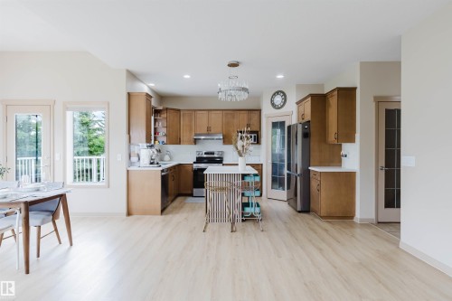 Open concept kitchen featuring wood-finish cabinetry, white countertops, and stainless steel appliances - 2236 Garnett Court Nw, Edmonton, AB 