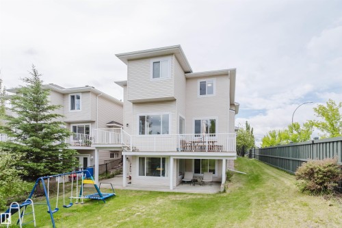 Expansive backyard featuring a large elevated deck, ground-level patio, and a sloped lawn - 2236 Garnett Court Nw, Edmonton, AB 