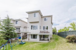 Expansive backyard featuring a large elevated deck, ground-level patio, and a sloped lawn - 