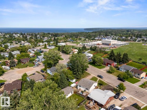 Aerial perspective showcasing a residential area with varied housing styles, mature trees, and paved streets - 1801 Forest Drive, Cold Lake, AB - Outdoor With View