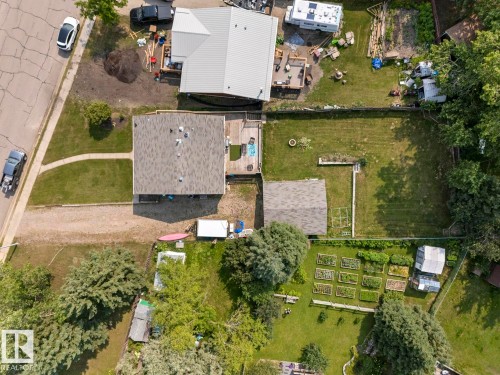 Spacious property featuring a main residence with a shingled roof, a secondary structure with a shingled roof, and a large green space - 1801 Forest Drive, Cold Lake, AB - Outdoor With View