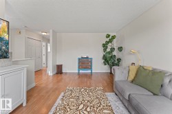 Living area featuring light wood-finish flooring, neutral wall tones, and a textured ceiling - 