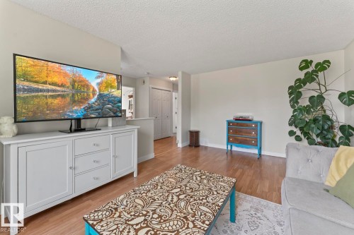 Living area featuring wood-finish flooring, light neutral wall paint, and a built-in half-wall partition - 1801 Forest Drive, Cold Lake, AB - Indoor Photo Showing Living Room