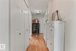 Hallway featuring wood-finish flooring and light-toned walls - 