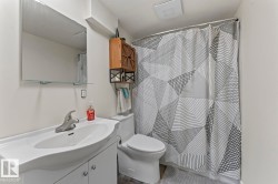 White bathroom vanity with an integrated sink and chrome faucet, featuring a wall-mounted mirror with an integrated glass shelf - 