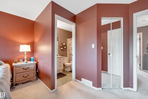Carpeted flooring, mirrored closet doors, and painted interior walls - #13 6608 158 Av Nw, Edmonton, AB 