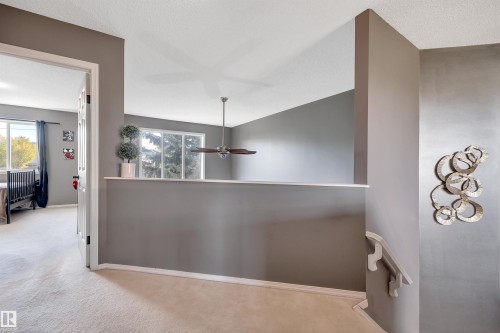 Split-level interior featuring a ceiling fan, light-colored carpeting, and a window with white trim - #13 6608 158 Av Nw, Edmonton, AB 