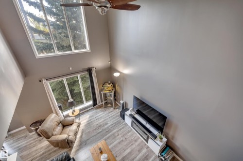 Vaulted ceilings with a ceiling fan, wood-finish flooring, and large windows - #13 6608 158 Av Nw, Edmonton, AB 