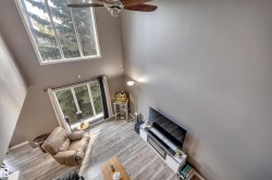 Vaulted ceilings with a ceiling fan, wood-finish flooring, and large windows - 