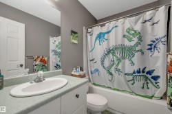 White vanity with an integrated oval sink, paired with a white built-in tub and shower - 