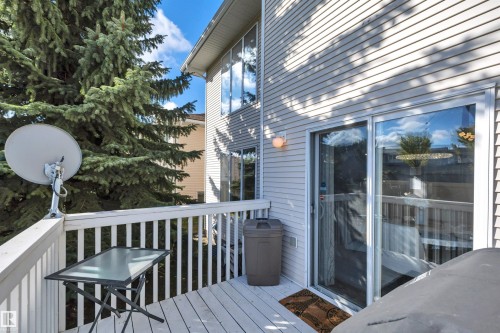 Outdoor deck with white painted railings and privacy landscaping - #13 6608 158 Av Nw, Edmonton, AB 