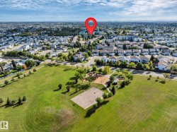 Expansive parkland featuring a large open field, playground, and paved sports court - 