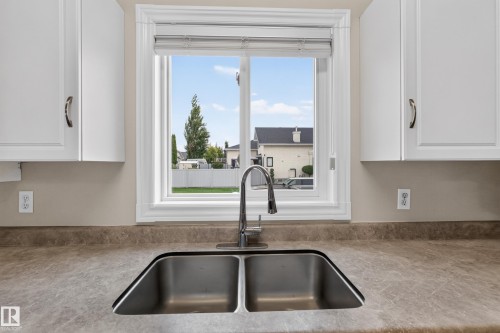 Double basin stainless steel sink with a gooseneck faucet - 365 Hollick-Kenyon Road Nw, Edmonton, AB 
