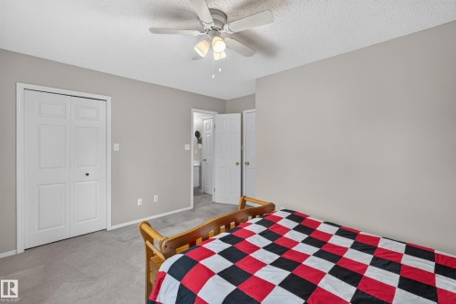 Carpeted flooring with light gray walls, a ceiling fan with integrated lighting, and a closet with bifold doors - 365 Hollick-Kenyon Road Nw, Edmonton, AB 