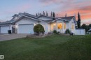 Expansive front lawn, two-car garage, white vinyl siding, bay window, and a white privacy fence - 365 Hollick-Kenyon Road Nw, Edmonton, AB 