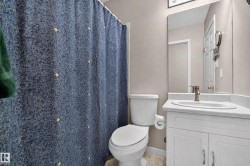 White vanity with panel-front cabinetry, single basin sink, and brushed nickel faucet - 