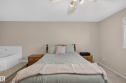 Built-in jetted tub with white tile surround, ceiling fan with integrated lighting, and a window with blinds - 