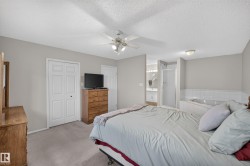 Recessed jetted tub with tiled surround, separate shower with glass enclosure, single vanity with integrated sink, and ceiling fan with lighting - 