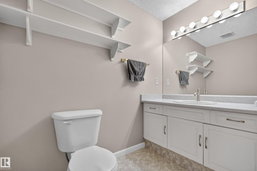 White vanity with integrated sink, full-width mirror, and overhead vanity lighting - 365 Hollick-Kenyon Road Nw, Edmonton, AB 