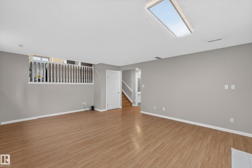 Recessed ceiling light panel, wood-finish flooring, half-height decorative railing, and white interior doors - 365 Hollick-Kenyon Road Nw, Edmonton, AB 