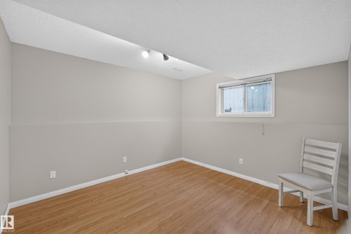 Light-toned wood-finish flooring, neutral wall paint, and a white-framed window - 365 Hollick-Kenyon Road Nw, Edmonton, AB 